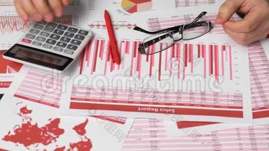 商务会计使用计算器计算办公桌上的财务。 企业财务会计理念.. 红色报告